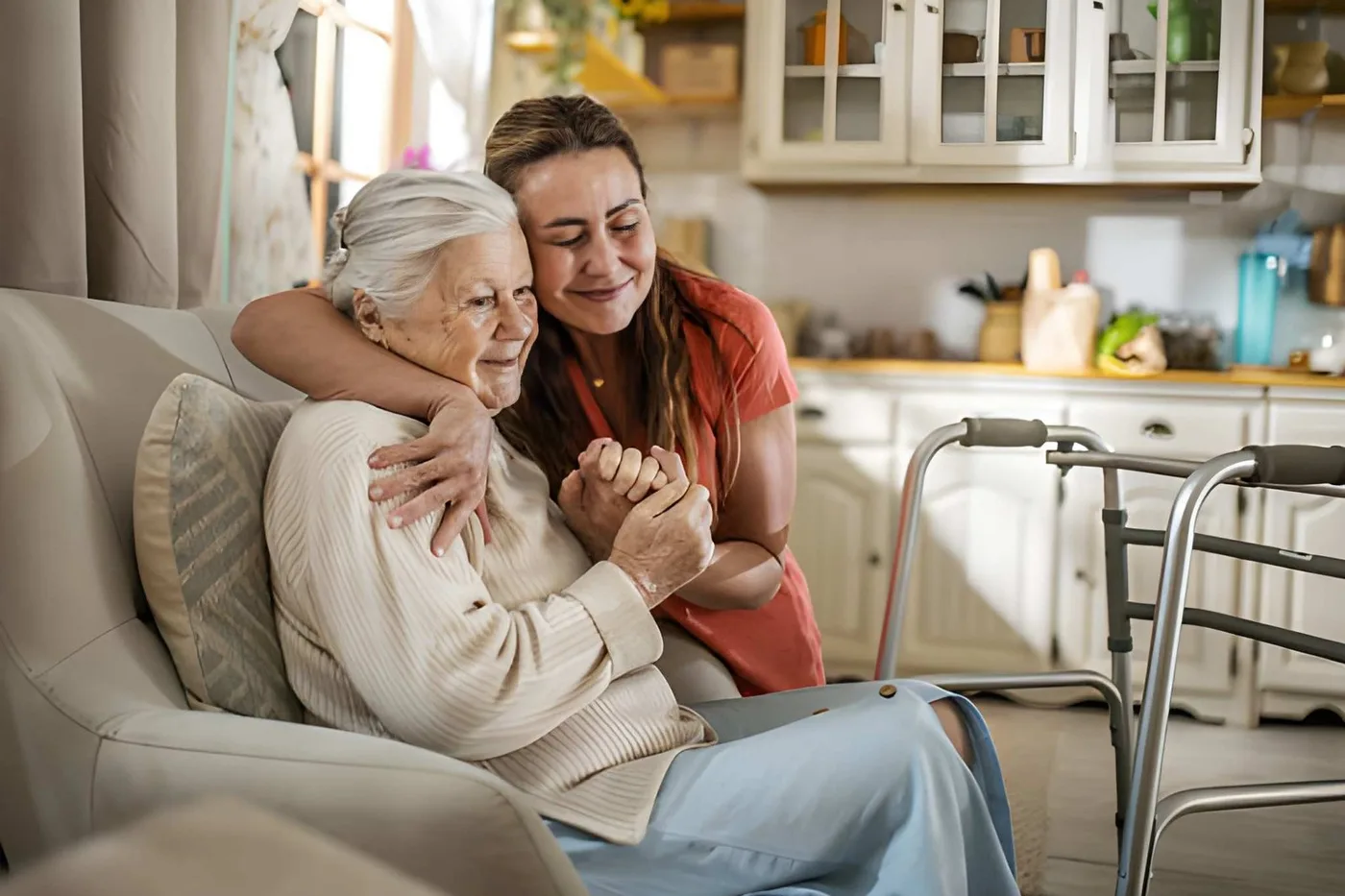 A caregiver offering a reassuring hug to an older woman at home